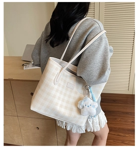 Checkerboard pattern tote bag with blue star charm shown on shoulder for daily commute