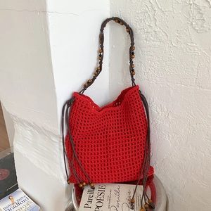 Vue détaillée du sac filet en crochet rouge avec sangle en perles de bois et franges