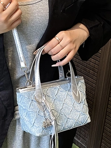 Fashionable light blue quilted crossbody bag with metallic sheen and silver handles
