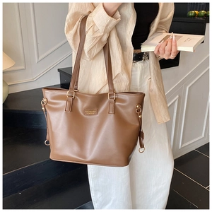 Detailed view of brown PU leather tote bag with metallic hardware and shoulder straps