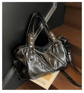 Dettaglio della borsa tote in ecopelle nera con borchie argentate e cerniere decorative