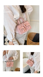 Détail du sac à bandoulière rose Y2K avec poches multiples et rivets sur le modèle