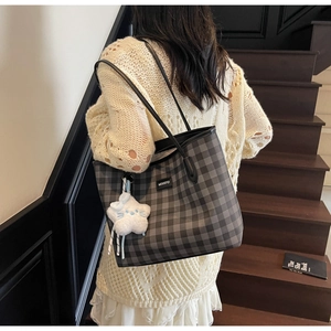 Macro detail of checkered tote bag with MEIGEFEI logo brand tag and star plush charm