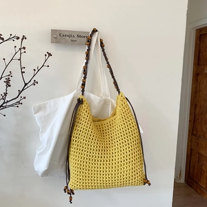 Détail du sac fourre-tout tissé creux avec bandoulière perlée et maille jaune gingembre