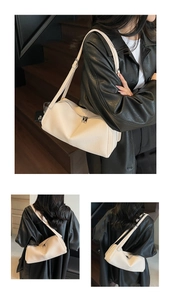 Detail of cream shoulder bag featuring pebbled leather texture and dual zipper closure