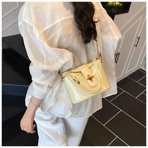 Beige glänzende Beuteltasche getragen zu einem modischen weißen Outfit