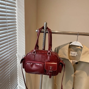 Detailansicht der weinroten Lackleder-Bowlingtasche mit mehreren Taschen und Silberbeschlägen