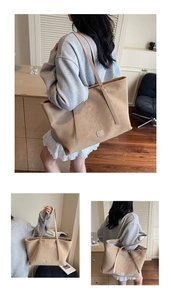 Détail du grand sac cabas en daim kaki avec bandoulière réglable et logo en cuir gaufré