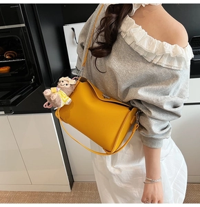 Detail of yellow lychee pattern leather shoulder bag with a cute sheep doll pendant charm