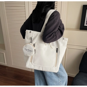 Detailed side view of white large capacity canvas tote bag with round coin purse accessory