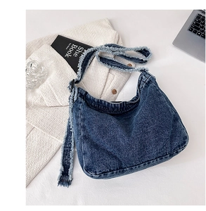 Détails du sac hobo en denim bleu marine avec des bords effilochés au style vintage