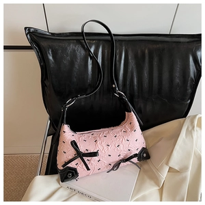 Close-up of pink puff texture handbag with black bow detailing and leather trim