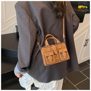 Détail du sac Boston marron vintage avec design multi-poches et boucles métalliques