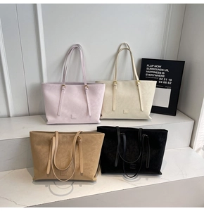 Détail de quatre grands sacs cabas en daim en violet, blanc, kaki et noir avec logo