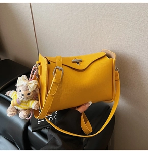 Detail of yellow lychee texture bag with silver T-lock and cute bear plush charm