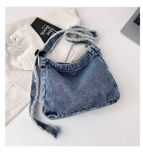 Détail du sac hobo en jean délavé bleu avec des finitions tendance à bords effilochés