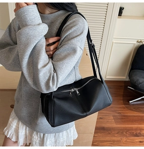 Close-up of black lychee grain leather shoulder bag with sleek silver double zippers