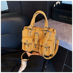 Gros plan détaillé d'un sac Boston jaune vif avec plusieurs poches et boucles argentées