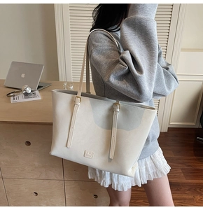 Détail du grand sac cabas crème montrant le design spacieux et la texture en similicuir