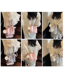 Detailaufnahmen der Damen-Beuteltasche mit Karomuster und niedlichem Plüsch-Anhänger