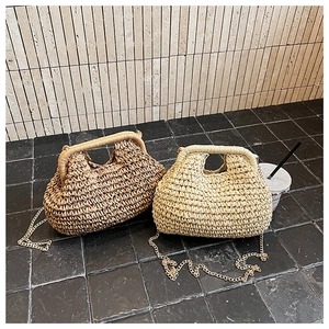 Détail de la texture d'un sac en paille tissé main avec bandoulière chaîne dorée
