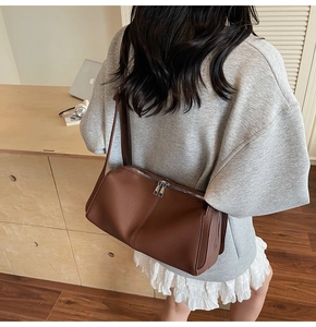 Detailed side view of brown lychee grain leather shoulder bag with silver double zippers