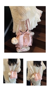 Detail of pink plaid bucket bag with plush lamb charm on outdoor wooden steps