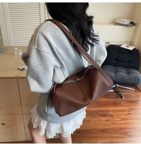 Detailed view of brown lychee grain leather shoulder bag with silver metal zipper closure