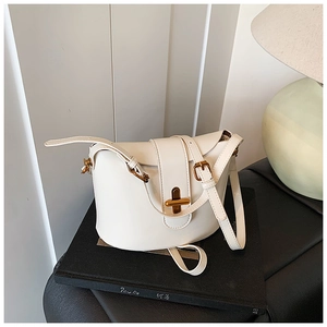 Detailansicht der cremefarbenen Beuteltasche mit elegantem goldenem T-Drehverschluss
