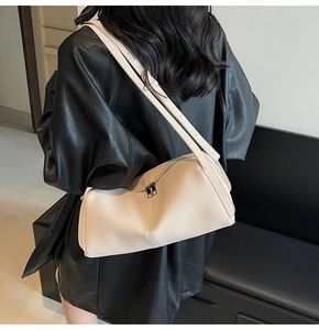 Detailed macro view of the beige lychee pattern leather and dual zipper design of the bag