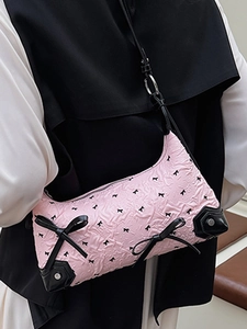 Chic pink bow-patterned shoulder bag with black trim and elegant ribbon details