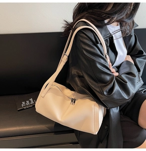 Detailed texture of creamy white pebbled leather on a chic minimalist underarm bag
