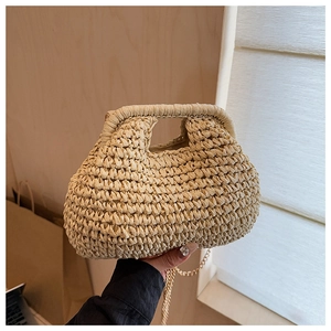 Détail d'un sac à main tressé beige en forme de nuage avec poignée et chaîne en métal