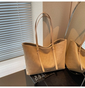 Détail du grand sac cabas abricot avec boucles dorées et texture de cuir synthétique mat