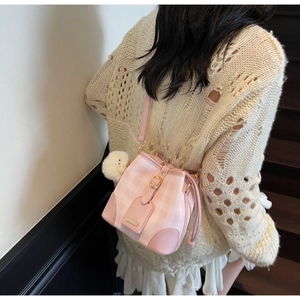 Pink and white checkered bucket bag with gold clasp and cute bird pendant on a model