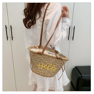 Détail du sac cabas en paille avec broderie Hello jaune et anses en cuir