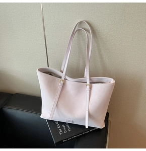 Détail d'un sac cabas rose clair avec bandoulières réglables et finitions dorées