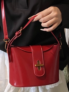Glänzende rote Beuteltasche mit goldener Metallschnalle und Lederriemen für Damen