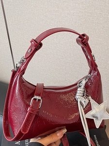 Sac à bandoulière en cuir verni bordeaux brillant avec breloques argentées et sangle