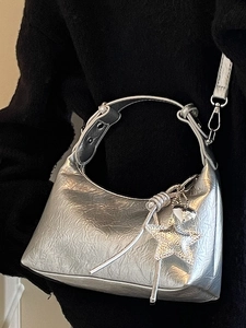Sac lune argenté métallisé avec texture plissée et pendentif étoile étincelant sur l'épaule