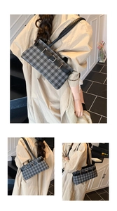 Detail of plaid shoulder bag with black leather strap and stylish buckle on indoor stairs