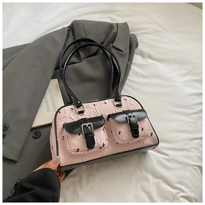 Detailed view of pink bag with rabbit prints and black leather pockets and silver buckles