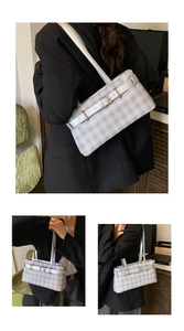 Detailed close-up of grey and white checkered shoulder bag with silver buckle accent