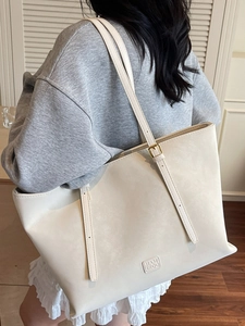 Grand sac cabas minimaliste blanc crème pour femme porté par un mannequin avec style