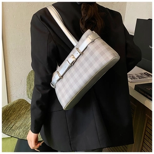Detail of silver checkered shoulder bag with metallic buckle on model back