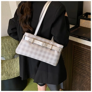 Detail of grey checkered underarm bag with belt buckle on a stylish black blazer
