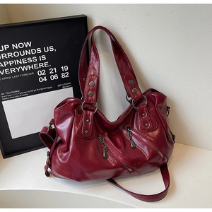 Dettaglio borsa hobo in morbida pelle bordeaux con doppie cerniere diagonali
