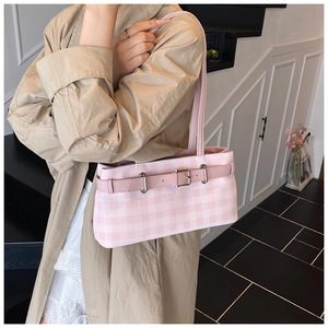 Detail of pink and white checkered shoulder bag with decorative buckle on a model