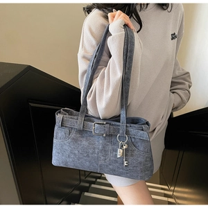 Detail of dark grey denim shoulder bag with decorative buckles and metal lock charm