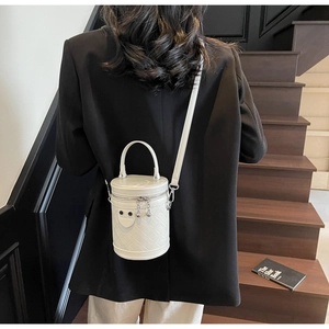 Detail einer weißen gesteppten Beuteltasche an einem Modell auf einer Holztreppe